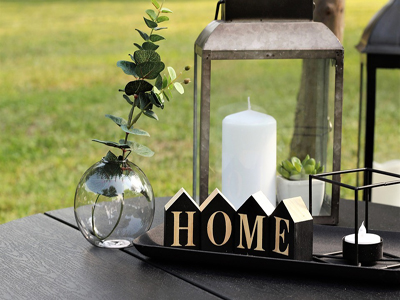 candle on a table outside with letters HOME