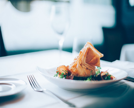 plate with a samosas on a white napkined table